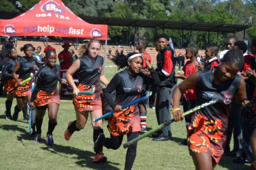 Image of Dundee High School's first team hockey girls running on to the field.