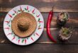 A sambrero plate near flowerpots and chilli peppers