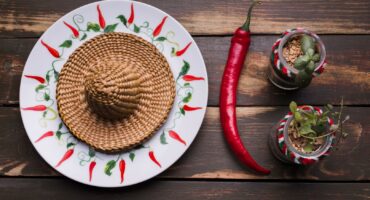 A sambrero plate near flowerpots and chilli peppers