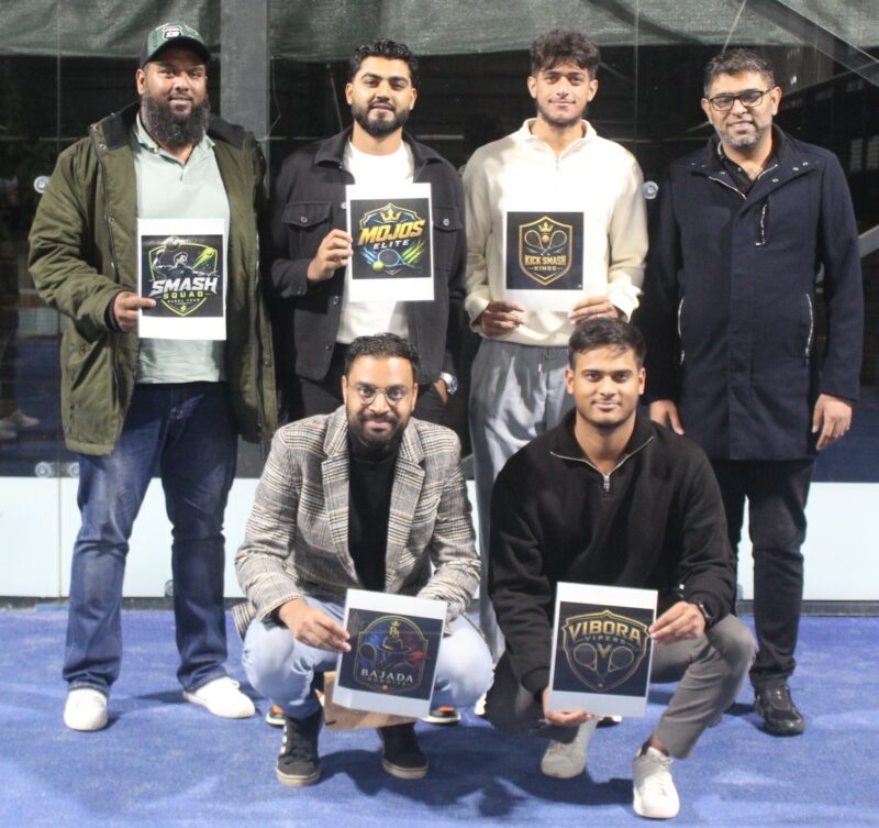 A group of padel players are photographed on a padel court at night.