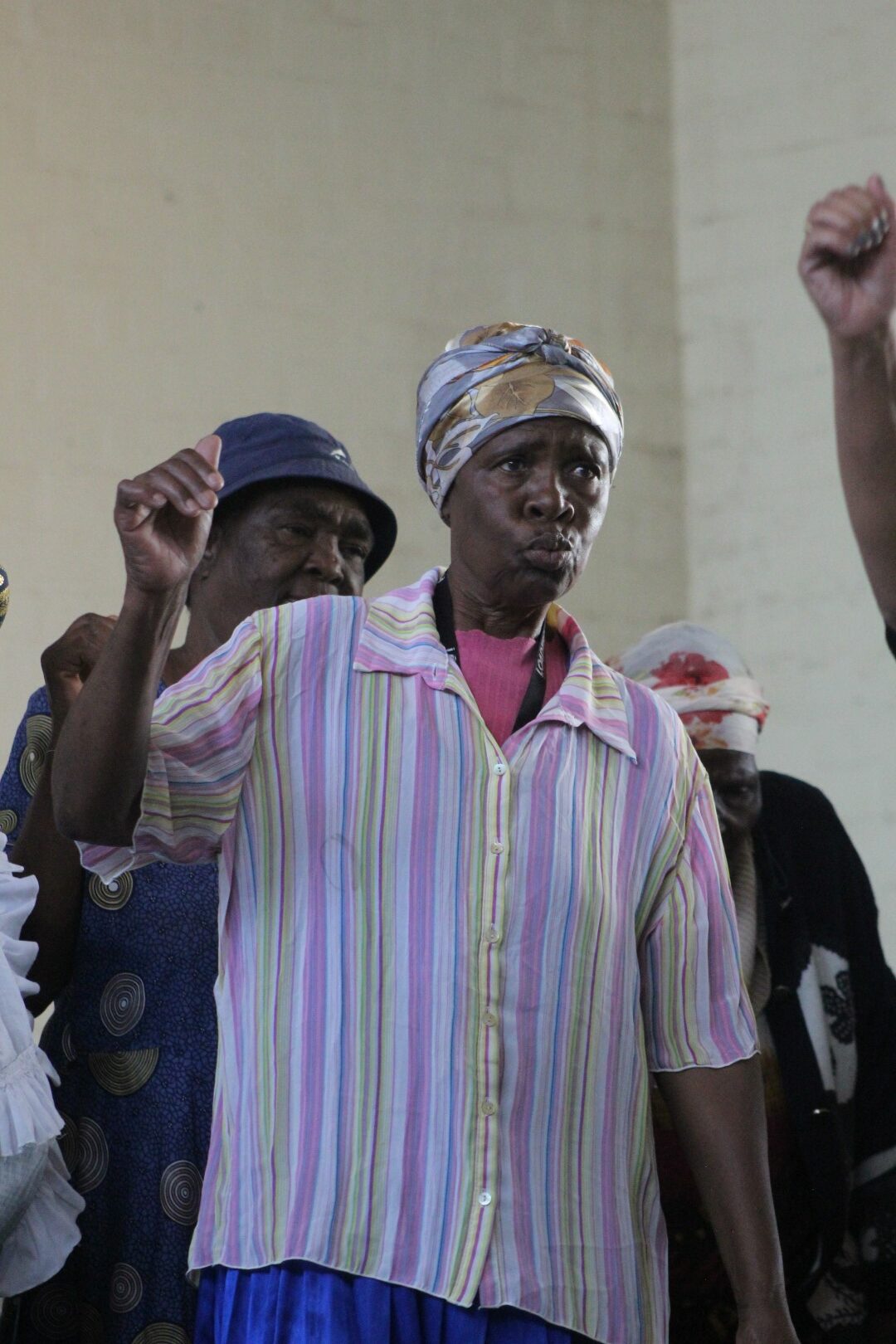 A woman is photographed dancing inside a community hall.