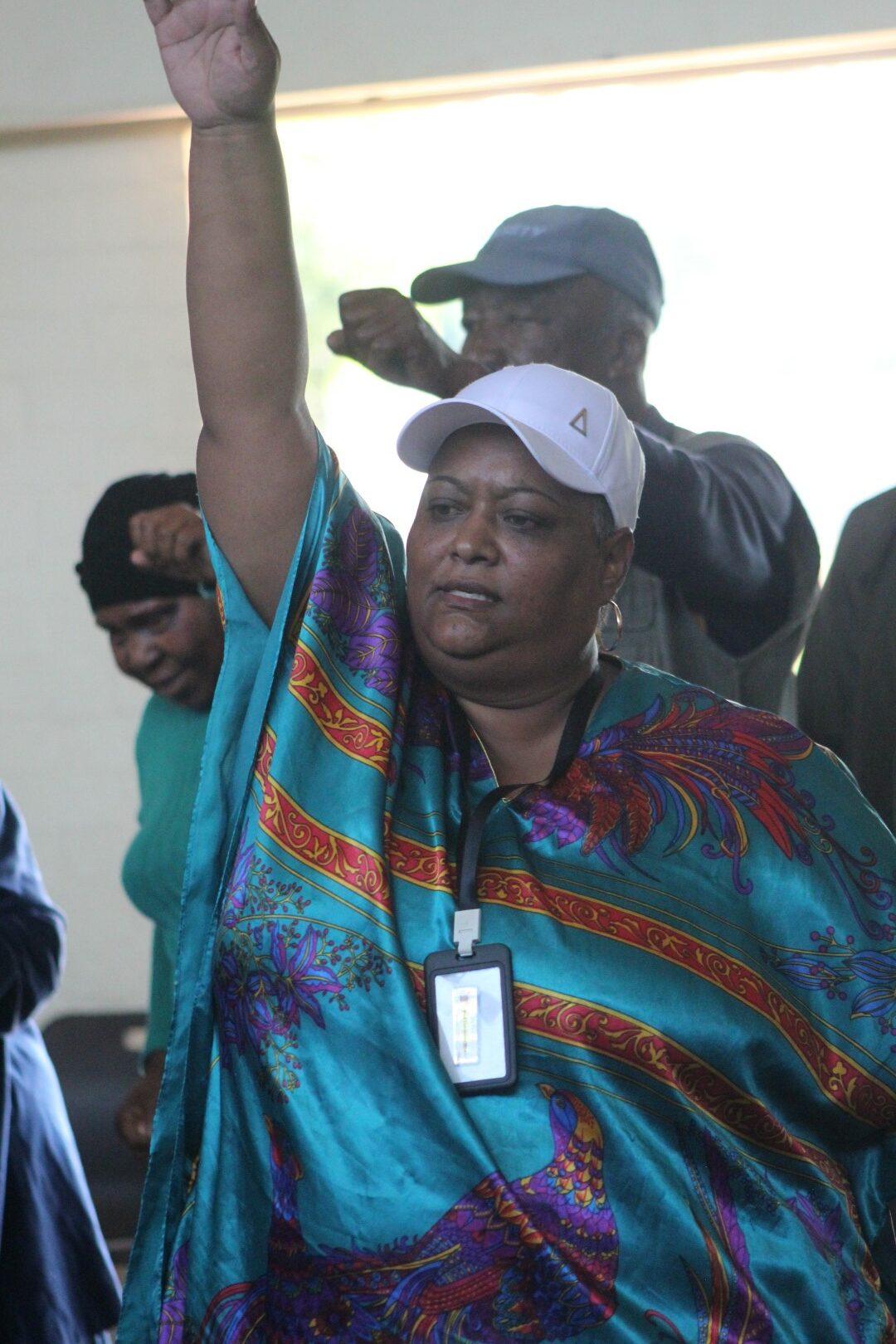 A woman is photographed dancing inside a community hall.