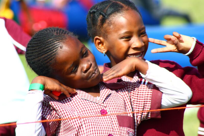 Two young children are photographed having fun at a loal fair.