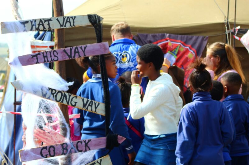 A group of school children are photographed getting ready to enter a haunted house tour at a local carnival.