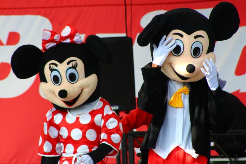 Minnie and Mickey Mouse. photographed against a red backdrop.