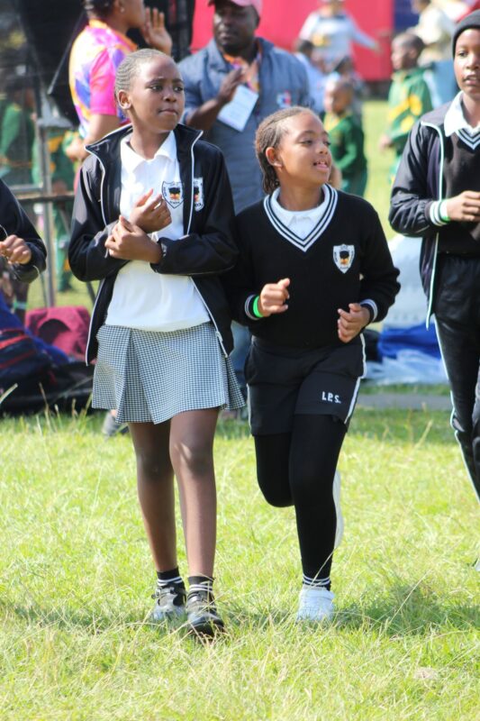 Two young school girls are photographed having a fun time at a local festival.