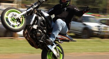 Motorcyclist performs wheelie stunt during bike rally