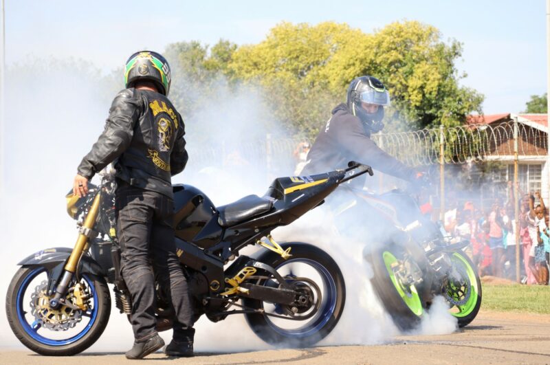 Two bikers are revving their engins to spin their rear wheels to burn tyres.