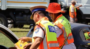 Traffic officers hand leaflet to driver during road safety campaign