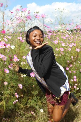 Image of Dundee model kneeling in among cosmos flowers.