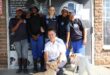 A group photo of Jenavieve Tinkler with the dedicated SPCA staff and two of their office pets.