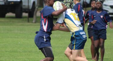 Image of two primary school rugby players running head on into each other.