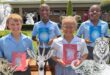 An image of Michaelis learners proudly holding donated books by Graham Root.
