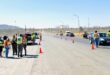 Image of a roadblock with officers and orange traffic cones.