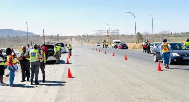 Image of a roadblock with officers and orange traffic cones.