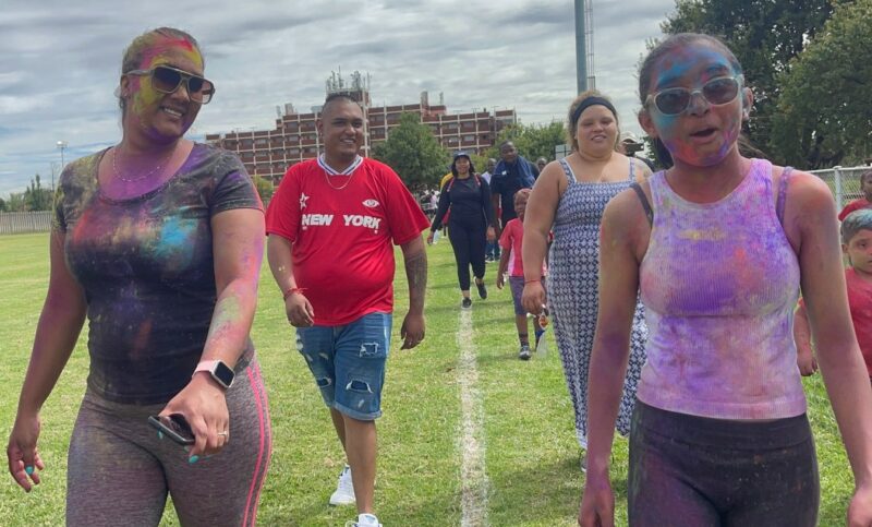 Various grown ups pose for a photo outside while busy exercising.