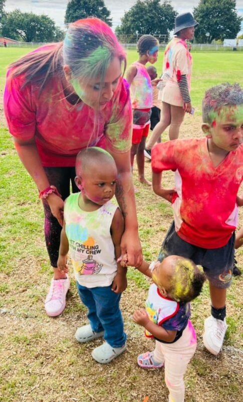 A photo of a group of people enjoying throwing colour powder during a colour run fun day.