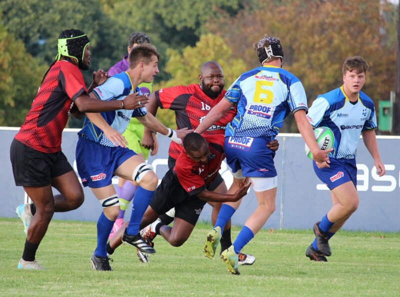 two rival rugby teams face off on a rugby field.