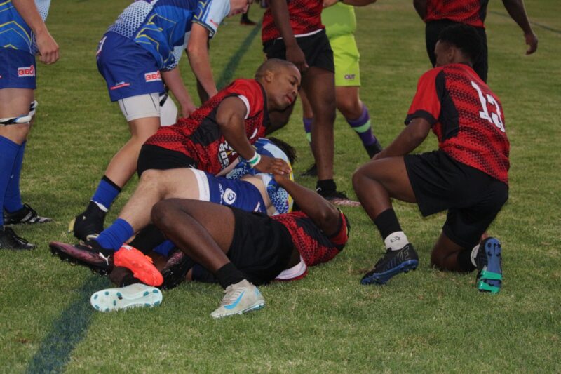two rival rugby teams face off on a rugby field.