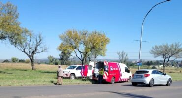 Two ambulance fleets are photographed along a busy road. two paramedics and an RTI Officer are also in the picture.