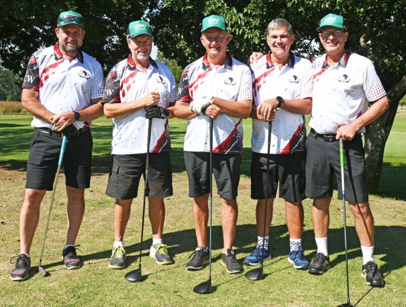 A group of men, dressed in golfing attire are photographed on a golf coarse.