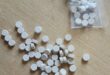 Image of mandrax tablets loose and in a packet on a table.