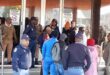 Image of SAPS officers and officials monitoring protesters outside the Dundee municipal offices.