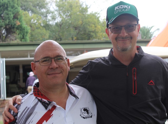 Two golfers are photographed outsde on the golf coarse.