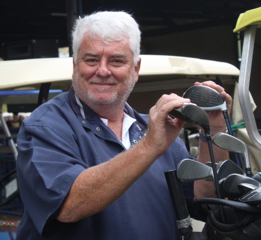 A golfer is photographed outsde on the golf coarse.