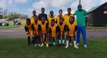 An image of little boys who play for Vryheid Sundowns FC with their coach Zweli Hlatshwayo.