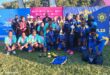 Image of SAPS ladies football team celebrating with trophy.