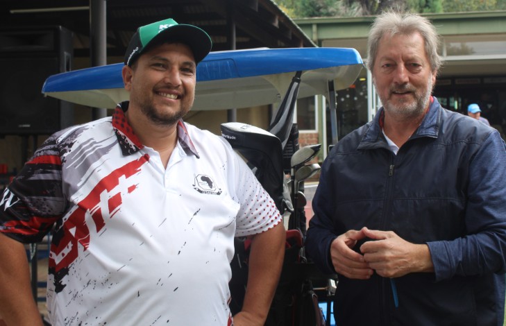 Two golfers are photographed outsde on the golf coarse.