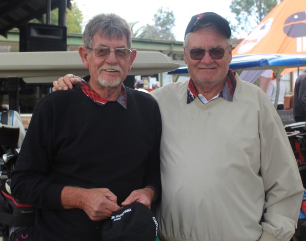 Two golfers are photographed outsde on the golf coarse.
