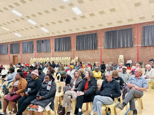 An image of residents of ward 8,9 and 10 of AbaQulusi Municipality, seated, listening to the mayor present 2026/27 IDP and draft budget at Cecil Emmett Hall.
