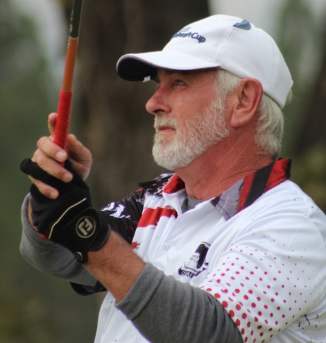 A golfer is photographed outsde on the golf coarse.