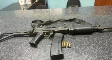 Image of R5 rifle and ammunition displayed on a SAPS charge office.