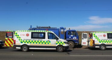 A photo of two ambulance fleets and a municipal truck along side the road.