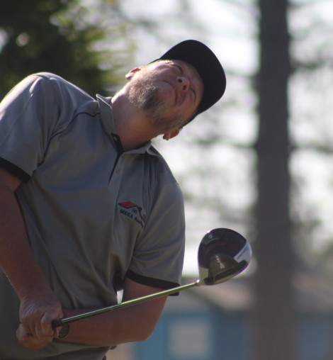 A golfer is photographed in action on the greens.