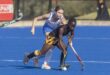 Image of two girls on an astro hockey pitch in a one on one chase.