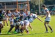 Image of 2 rugby teams tackling during a game.
