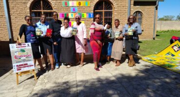 Am image of Methodist Church members, local authors and librarians holding reading books at the World Book Day celebration held in Mondlo.