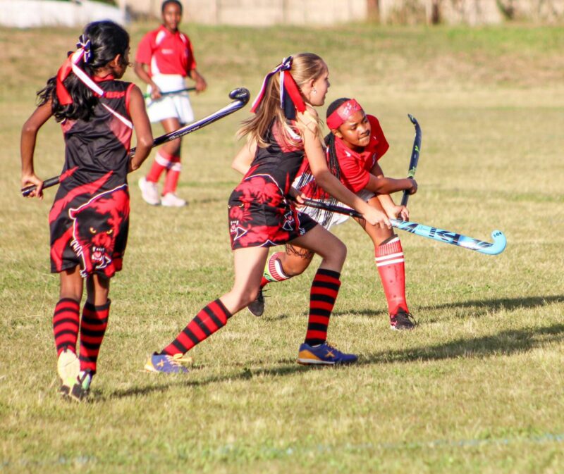 An image of Anesu Sithole with other hockey players, battling it out on the field.