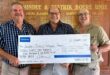 Image of Johan du Plessis (fund chairman), Andrew Adams (Virbac regional manager) and Fritz Botes (Dundee Farm Security manager) holding a symbolic cheque.