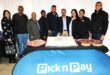 A group of people are photographed standing behind a blue pick n pay banner.