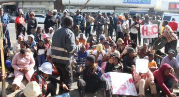 Image of protesters seated outside Umzinyathi's Dundee office.