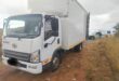 Image of a truck at the side of the road with a police van in the background.