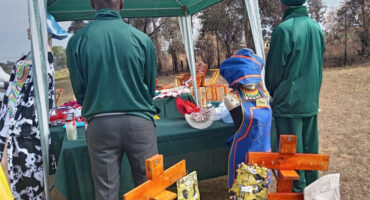 An image of two Inkanyiso Special School learners standing next to the items they hand-made at their Market Day.