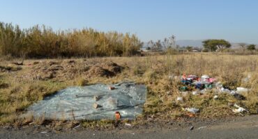 Image of dumped building rubble and shattered glass in a field on Albert Street, Dundee.