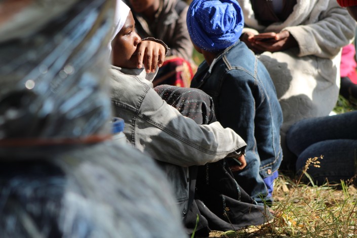 A photo take of a group of Malawian nationals hiding out of fear. their belongings are pictured as well.