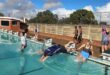 Image of people jumping into a pool.